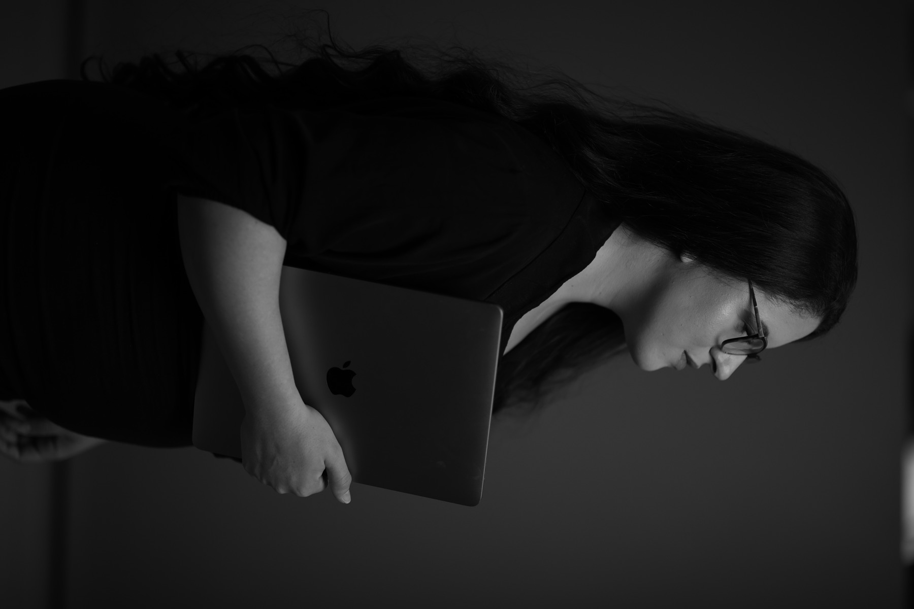 Gabriela Anício de perfil, segurando um notebook